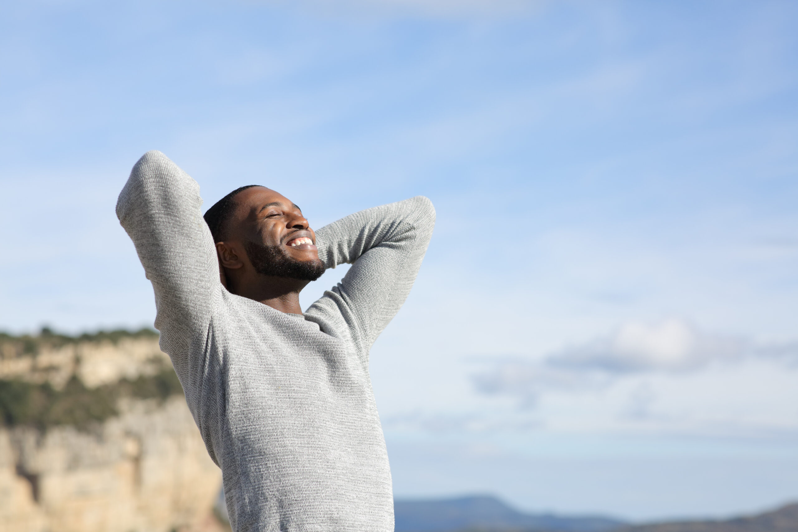 Relaxed man with black skin breathing in the mountain
